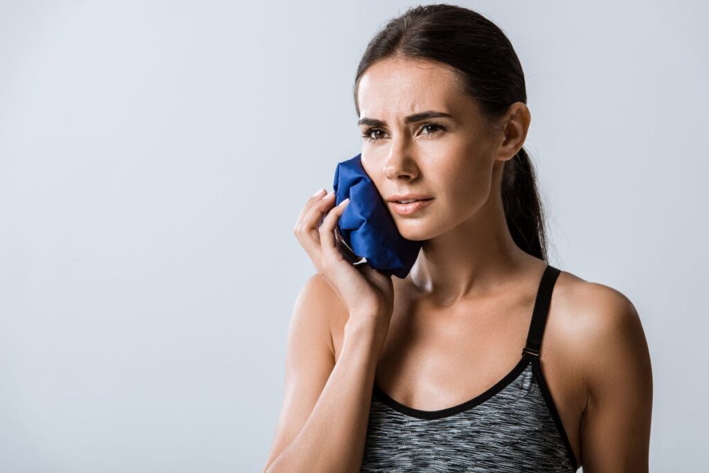 Woman using a cold compress before visiting an Emergency Dentist in Chelmsford