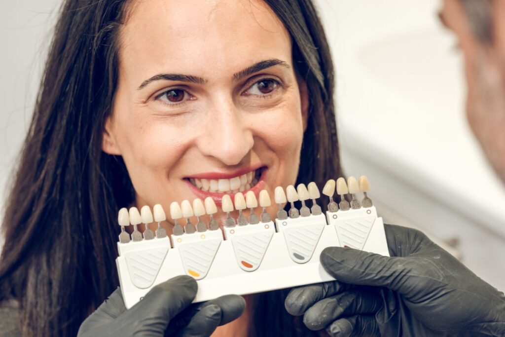Dentist comparing tooth shades during a Composite Bonding vs Veneers consultation