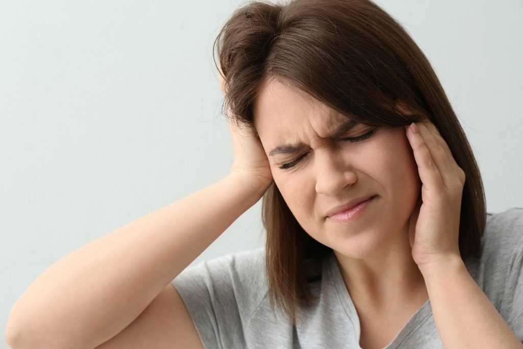 Woman experiencing jaw and tooth pain from a possible dental problem