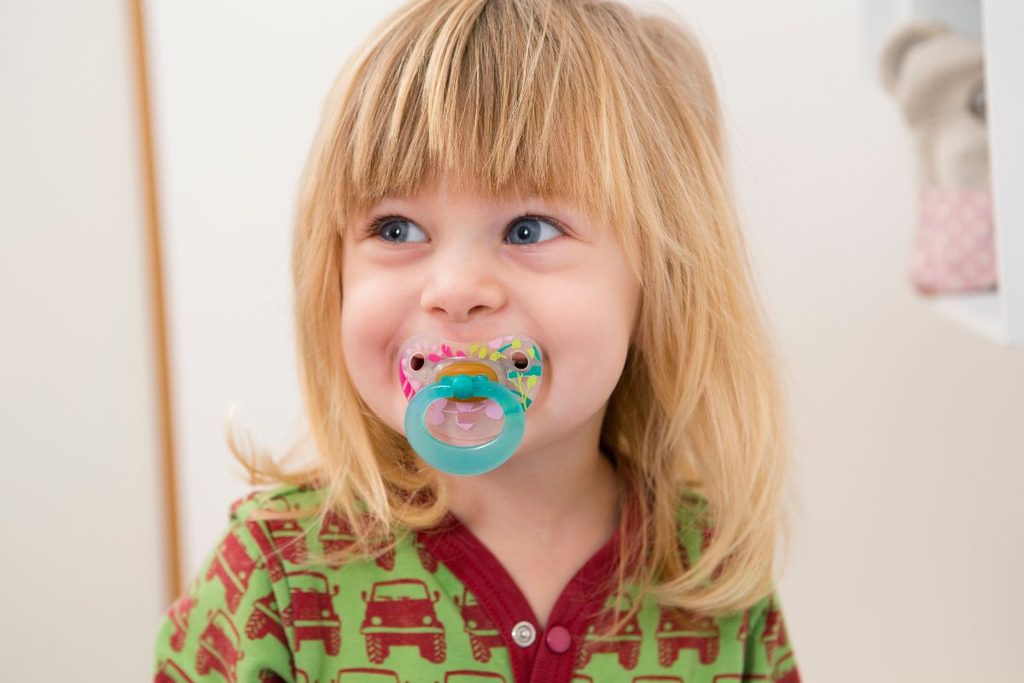 Child using a pacifier while developing healthy oral habits