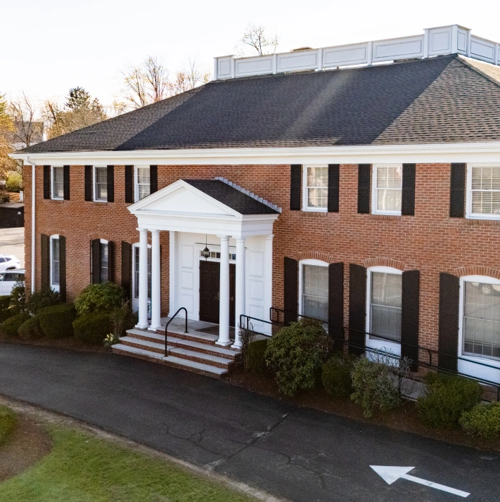 Exterior view of the Chelmsford Dental Associates brick building with white columned entrance