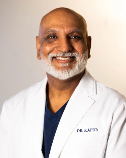Portrait of Dr. Kapur smiling in a white coat