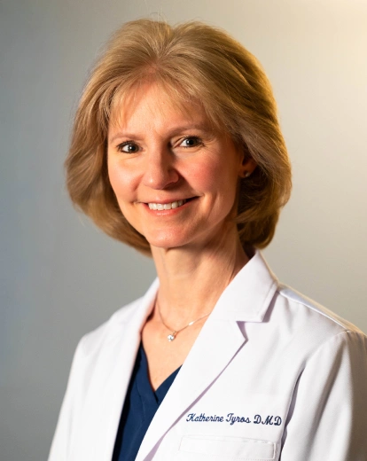 Portrait of Dr. Katherine Tyros smiling in a white coat