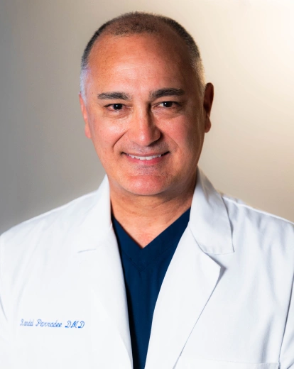 Portrait of Dr. Randal Perradee smiling in a white coat