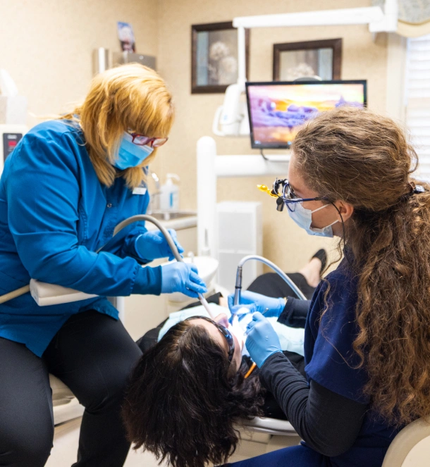Dental team performing a procedure on a patient in the dental chair