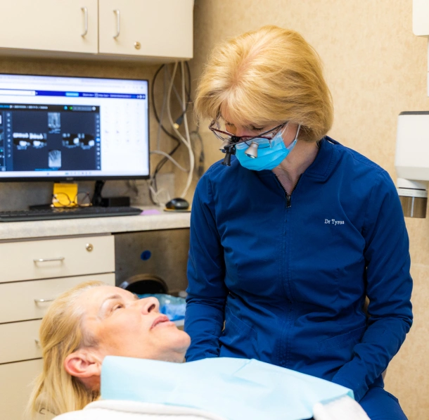 Dentist in mask and loupes examining a patient before a procedure